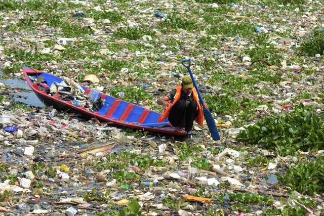 Seorang petugas membersihkan sampah yang menumpuk di kawasan Batujajar, Kecamatan Cihampelas, Kabupaten Bandung Barat. Foto : Donny Iqbal/Mongabay Indonesia