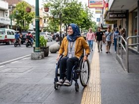 ilustrasi seorang penyandang disabilitas sedang berjalan di trotoar. (Foto: Gemini)