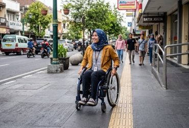 ilustrasi seorang penyandang disabilitas sedang berjalan di trotoar. (Foto: Gemini)